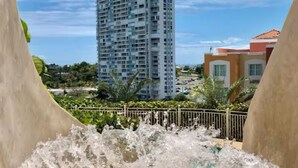 Una fuente de agua con un edificio alto al fondo.