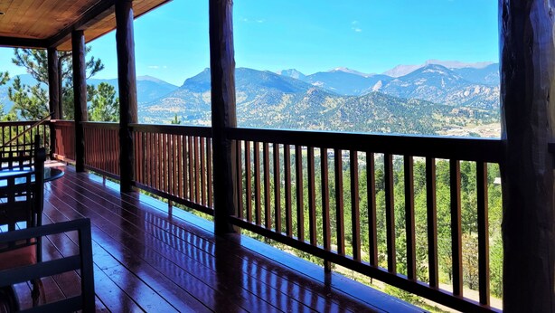 A wooden deck with a railing overlooking a mountainous landscape. - Mountain of Joy, 21-ZONE3029 (Estes Park)