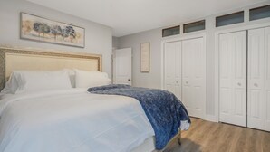 A bedroom with a bed, a painting, a wardrobe, and a door. - Urban Nest 7 mins from Edmonton downtown <br> (Edmonton)