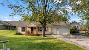 A single-story house with a front porch, a garage, and a well-maintained lawn.