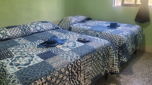 Two beds with blue patterned bedding and a remote control on one bed. - Hostal Sweet Dreams (Panajachel)