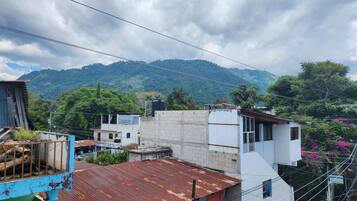 A residential area with buildings, a mountain in the background, and power lines.