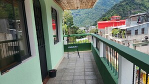 A balcony with a view of a mountain and a red building in the background. - Hostal Sweet Dreams (Panajachel)
