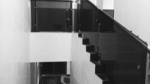 Una escalera moderna con barandillas de vidrio y un suelo reflectante.