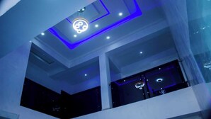 Un interior moderno con un diseño de techo geométrico e iluminación empotrada.
