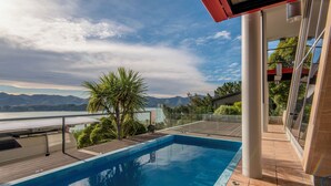 A swimming pool with a view of mountains and a body of water.