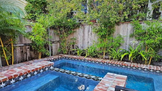 Una piscina rectangular con borde de ladrillo y detalles de azulejos en forma de estrella.