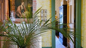 Una habitación con pared de ladrillo, un cuadro enmarcado, un mueble de madera y una mesa con un mantel tejido.
