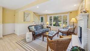 A living room with a sofa, chairs, a coffee table, a fireplace, and a window with a view of the outside. - Beachmore-Steps to Sandy Beach (Biddeford)