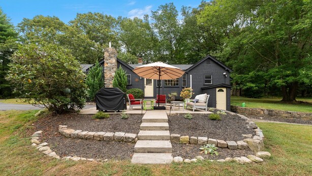 A house with a stone fireplace, outdoor seating, and a covered patio area. - Peaceful Oasis minutes to T.F. Green International Airport, Main Street & more (East Greenwich)