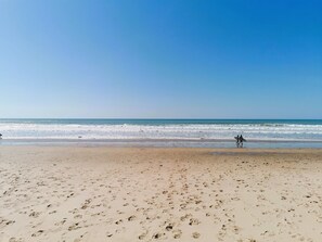 A beach with footprints leading to the water, a clear sky, and a calm sea. - La Petite Dune 800m from the beach (Bretignolles-sur-Mer)