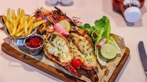A seafood platter with grilled shrimp, fries, and a side of ketchup. - Novel Suites And Resort (Jos)