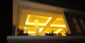 A modern building with illuminated interior lighting. - Novel Suites And Resort (Jos)