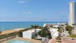 A high-rise hotel with a rooftop pool and a view of the beach and ocean. - Oceanfront apartment, swimming pool, automatic check-in (Guayaquil)