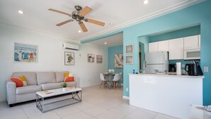 A modern living room with a sofa, coffee table, and dining area. - CASA DEL MAR HOLLYWOOD (Hollywood)