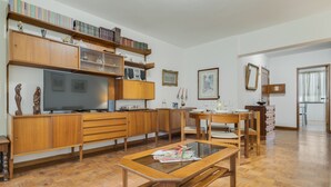 A spacious living room with wooden furniture, a television, and bookshelves. - Refugio Madeirense by Atlantic Holiday (Funchal)