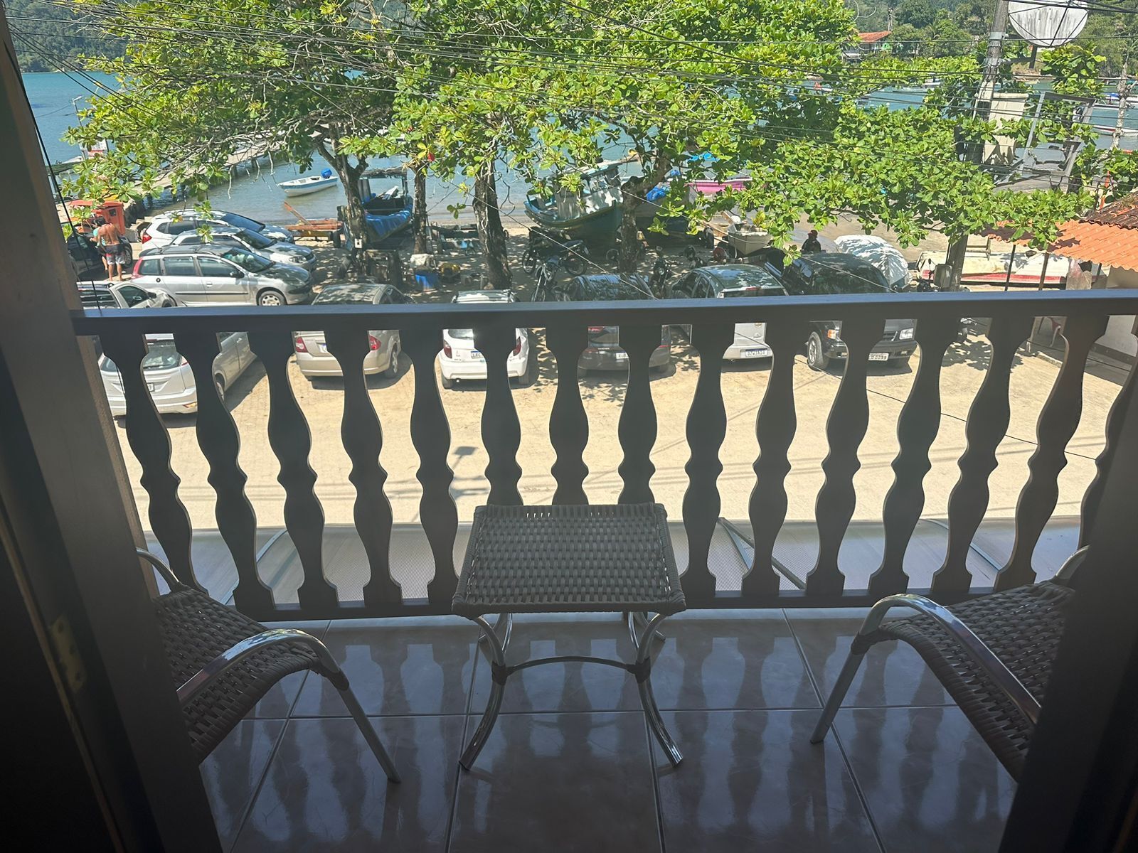 Un balcón con vista a un estacionamiento y un árbol.