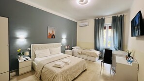A hotel room with two beds, a desk, a chair, a TV, and a window with curtains. - Bonaini Relax B&B (Pisa)