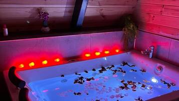 Una cabaña de madera con un jacuzzi grande y rectangular.