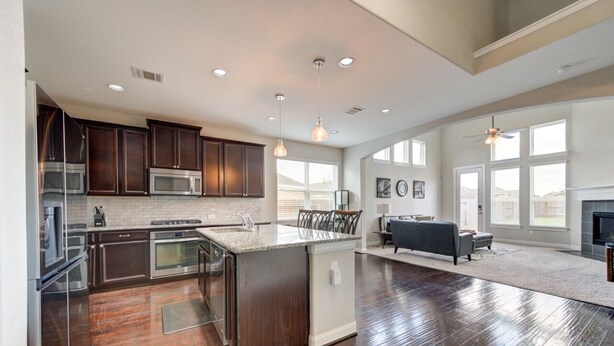 A spacious kitchen with dark wood cabinets, stainless steel appliances, and a large island. - 5-STARS HOST! Spacious 4-2.5 Pearland Clear Lake Friendswood. World Cup 2026 (Houston)