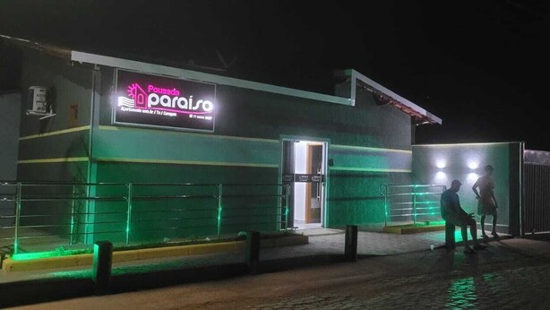 A building with a neon sign reading "Pousada Peraiso" indicating it is a lodging establishment. - Pousada Paraiso (Wanderley)