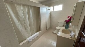 Un baño con bañera, inodoro, lavabo y zona de ducha.