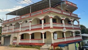 Un edificio de dos pisos con balcones y ventanas arqueadas, con la leyenda 'BUSHMAN'.