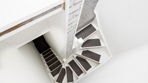 A white staircase with a black and white pattern, leading to a lower level.
