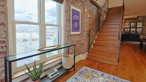 A staircase with wooden steps and a metal railing, leading to an upper floor.