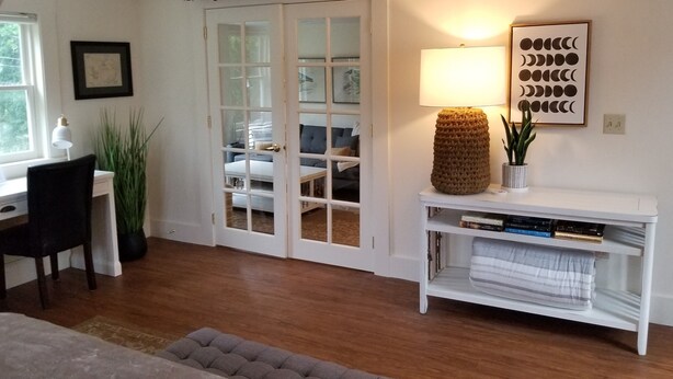A room with a desk, chair, and a bookshelf with books.