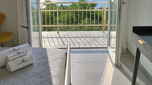 A balcony with a view of the sea, a bed with a patterned blanket, and a chair. - Apartment with sea-view balcony from which to admire magical sunrises. (Castro)