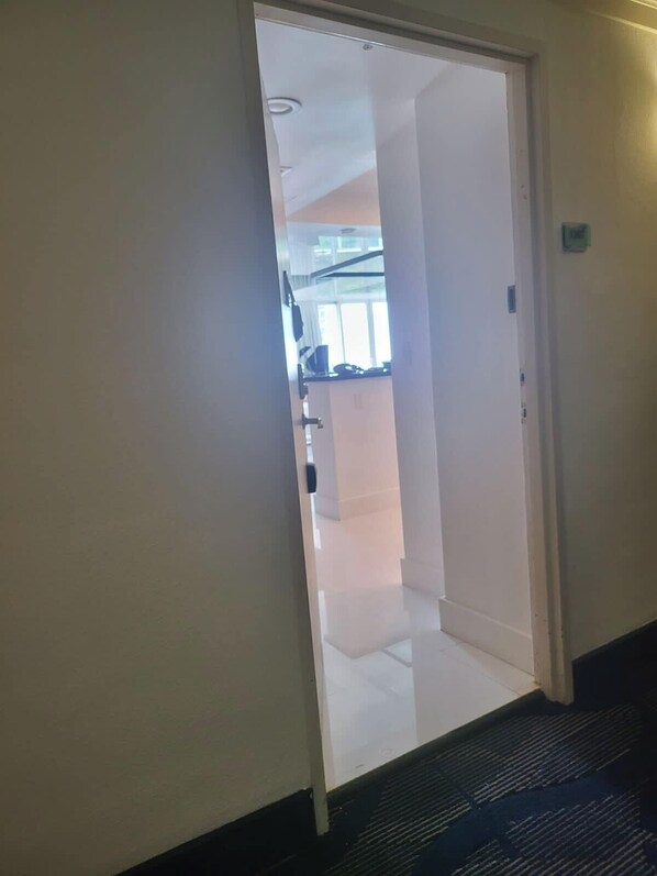 Una puerta que da a una zona de cocina con una ventana sobre el fregadero.
