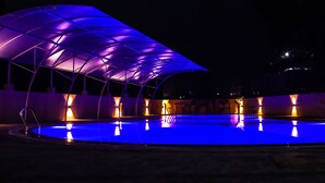 A swimming pool with a covered area and lights. - Nepalirika Hotel Biratchowk (Sundar Haraicha)
