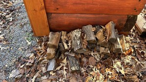 Une structure en bois dont la base est constituée de troncs d’arbres empilés.