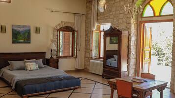 A bedroom with a bed, a table, and a chair.