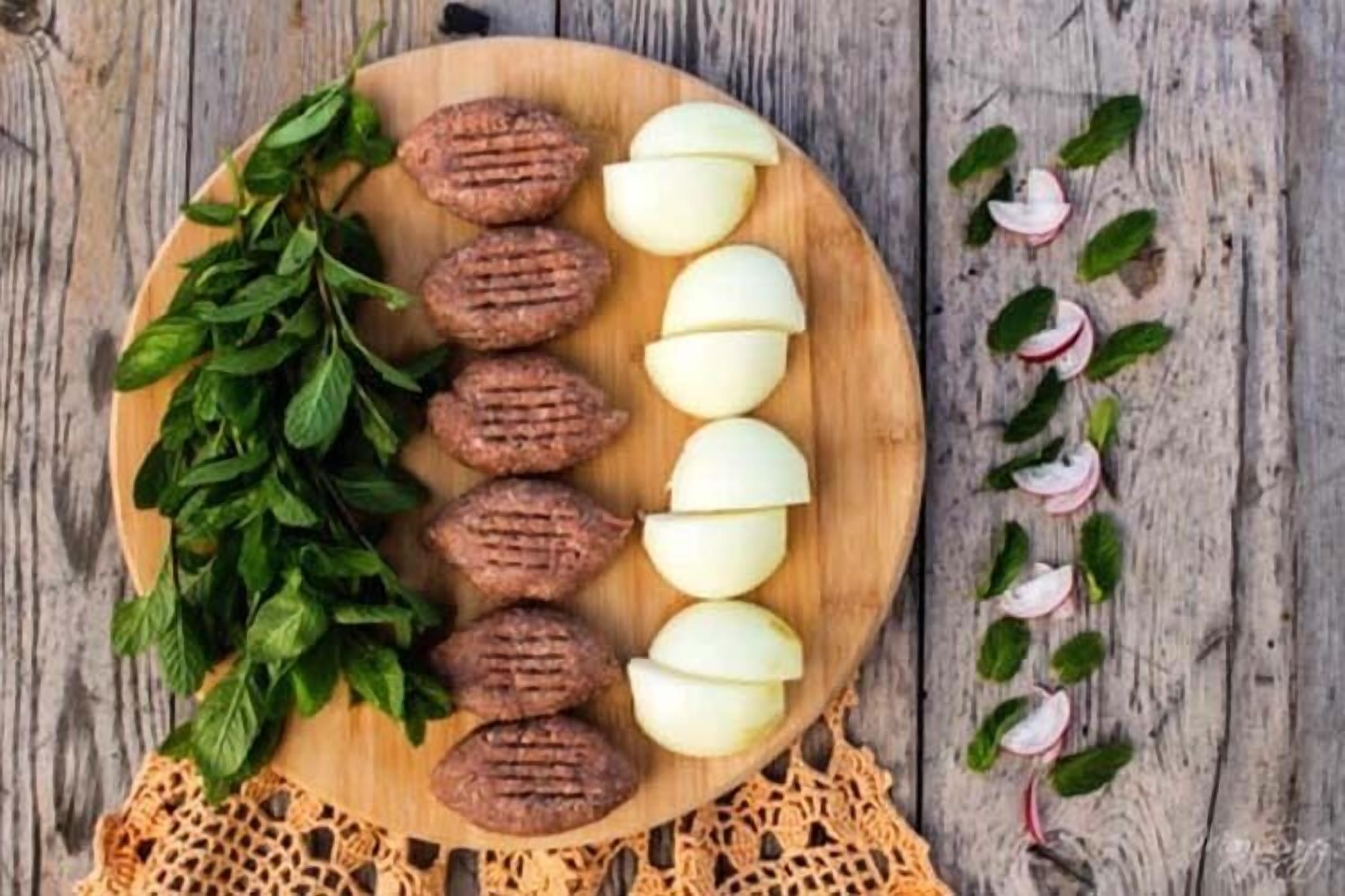 Un tagliere di legno con fettine di mele e mandorle, arricchito da foglie verdi e ravanelli a rondelle.