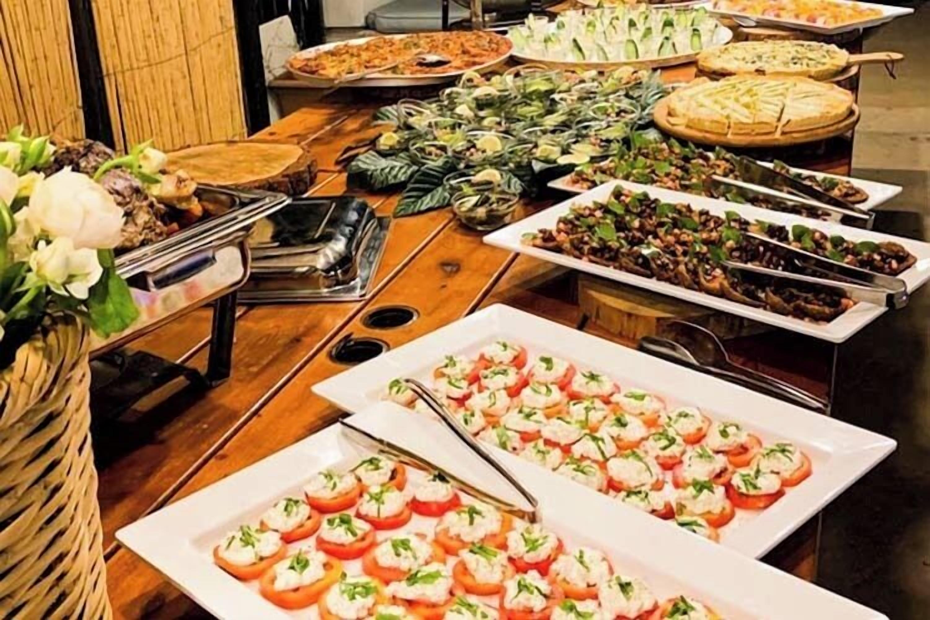 Une table de buffet proposant divers plats, notamment un grand plat d’assortiments et une variété de salades.