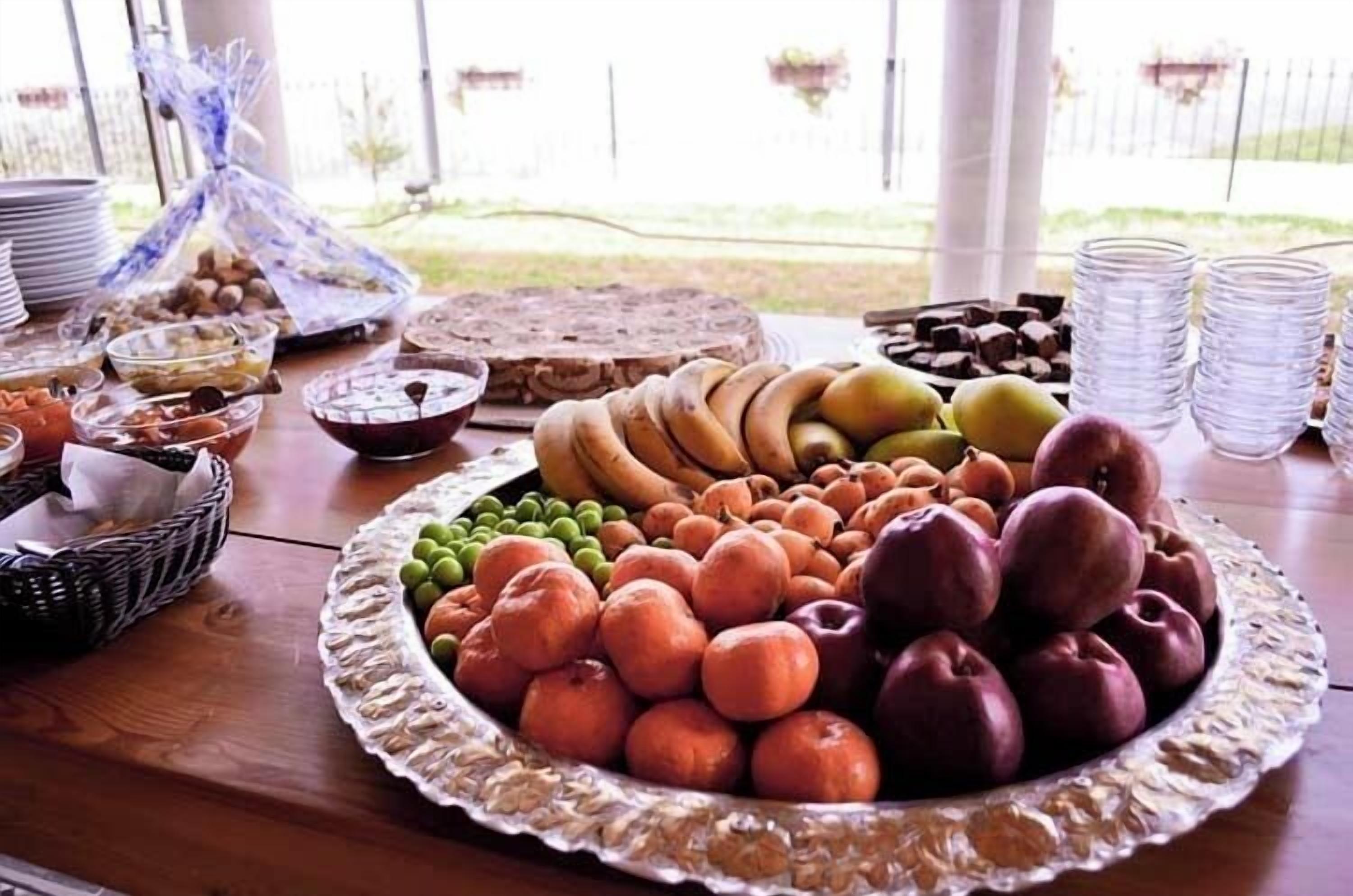 A table with various fruits and snacks, including apples, bananas, and pastries.