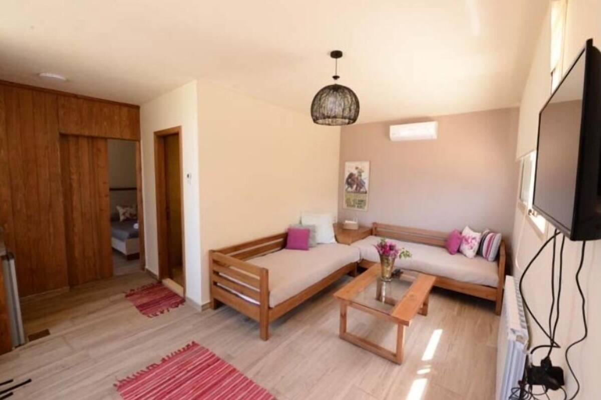 A living room with a sofa set, a coffee table, and a hanging light fixture.