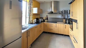 Une cuisine moderne avec des meubles en bois, des appareils électroménagers en acier inoxydable et une grande fenêtre.