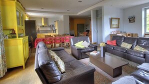 Un salon comprenant un canapé, une table basse et un coin repas avec des chaises et une table.