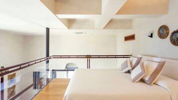 Una habitación de hotel moderna con una cama grande, un balcón de cristal y vistas a la ciudad.