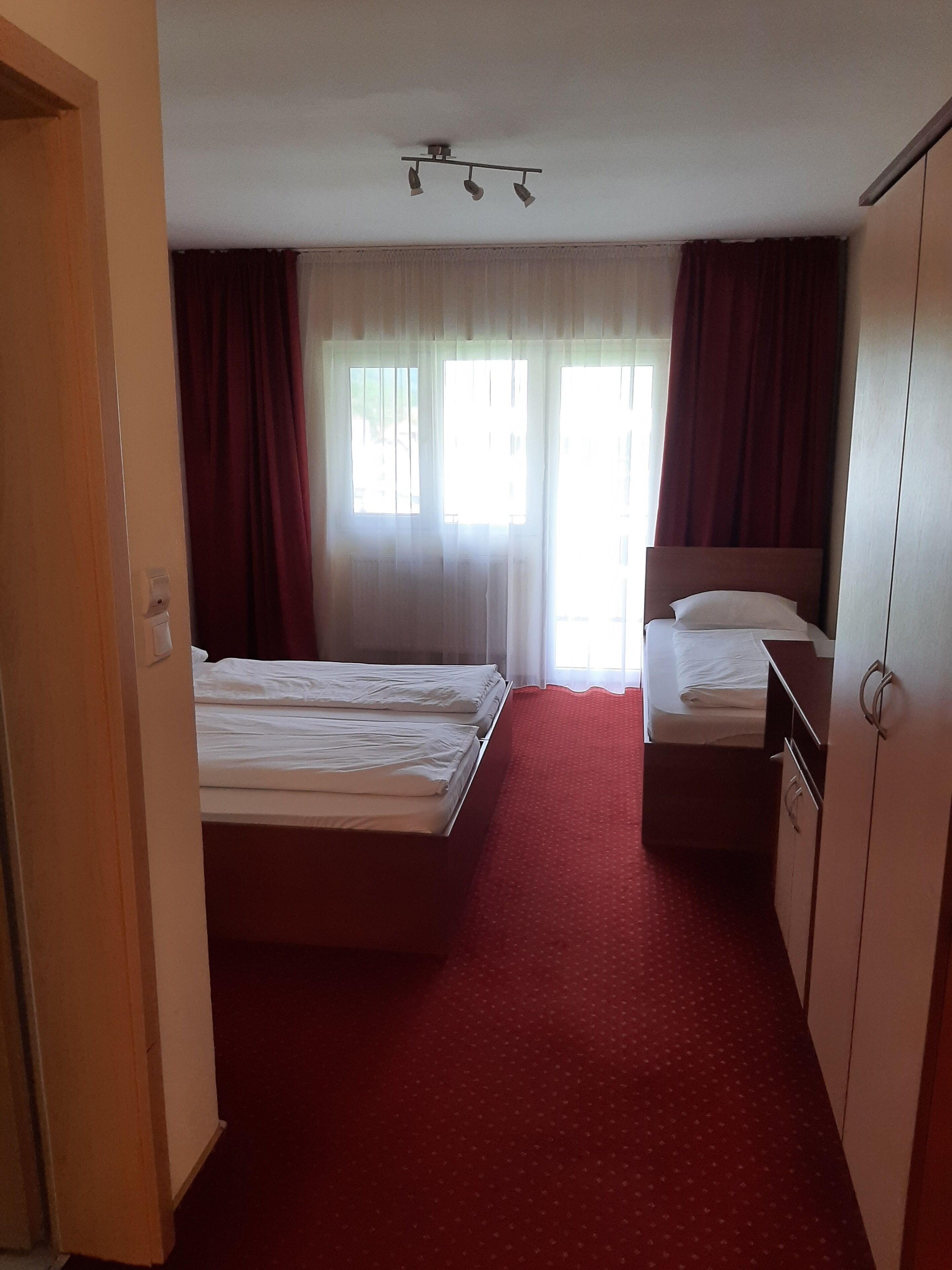 Une chambre d’hôtel avec un lit, un bureau et une armoire.