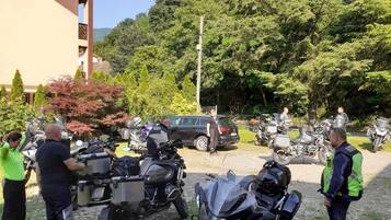A gravel parking area with motorcycles and a building in the background.