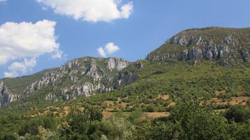A mountainous landscape with rocky cliffs and dense greenery.