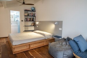 Un dormitorio con una cama de madera, una estantería, un globo terráqueo y una lámpara de escritorio.