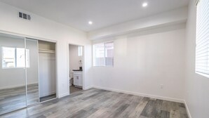 A spacious room with a large sliding door closet, a small kitchenette, and a large window with blinds. - Boutique HomeStay (Los Angeles)