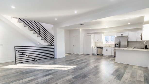 A spacious kitchen with white cabinets, a stainless steel refrigerator, and a modern design. - Boutique HomeStay (Los Angeles)