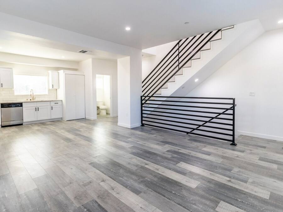 A spacious kitchen with white cabinets and a stainless steel refrigerator.