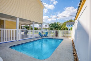 A swimming pool with a white fence and two blue chairs. - 4BD Ocean View Private Beach Home -Heated Saltwater Pool- Elevator (North Myrtle Beach)